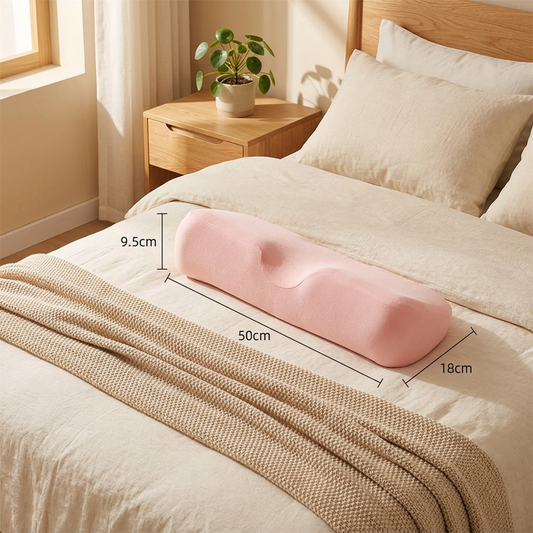 Blush pink contour memory foam pillow on a cream linen bed in a warm minimalist bedroom